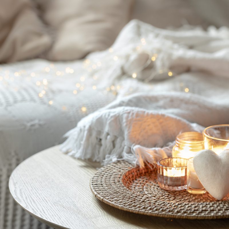 Romantic composition for Valentine's Day with candles in the interior of the room. Copy space.